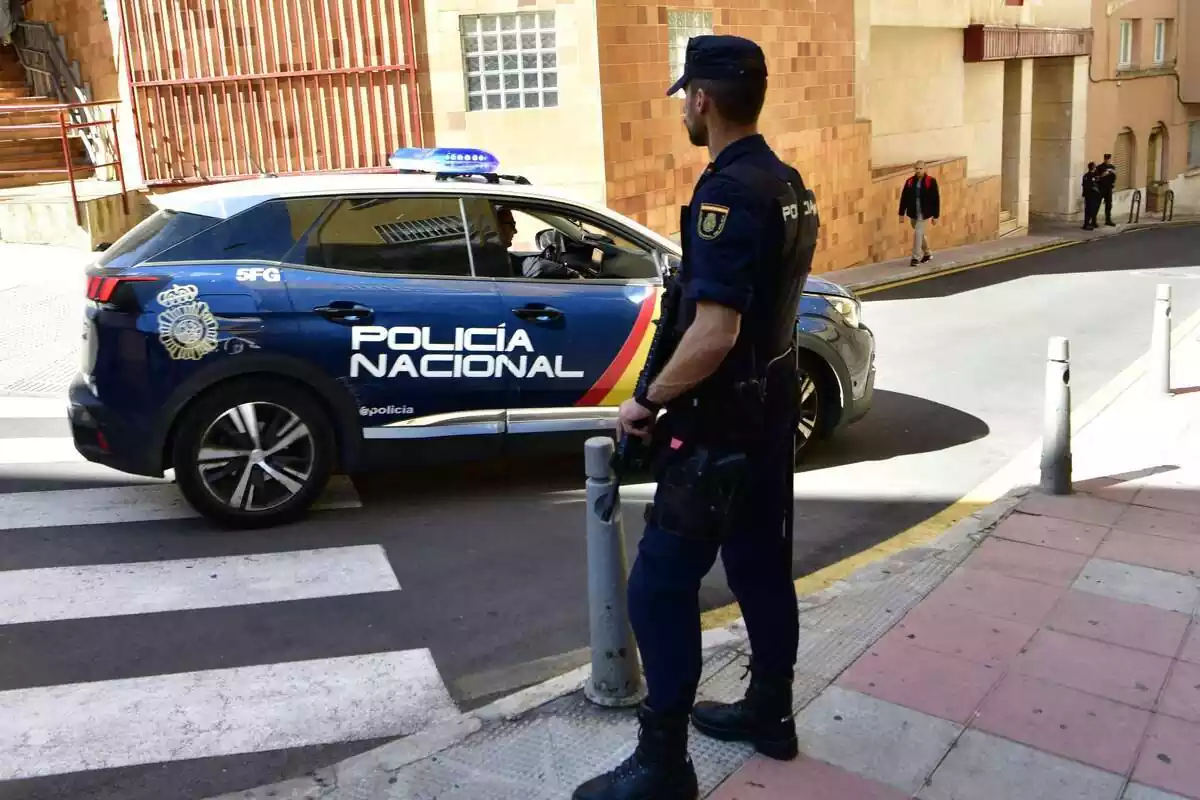 Un agent i vehicle de Policia Nacional participen en un operatiu policial