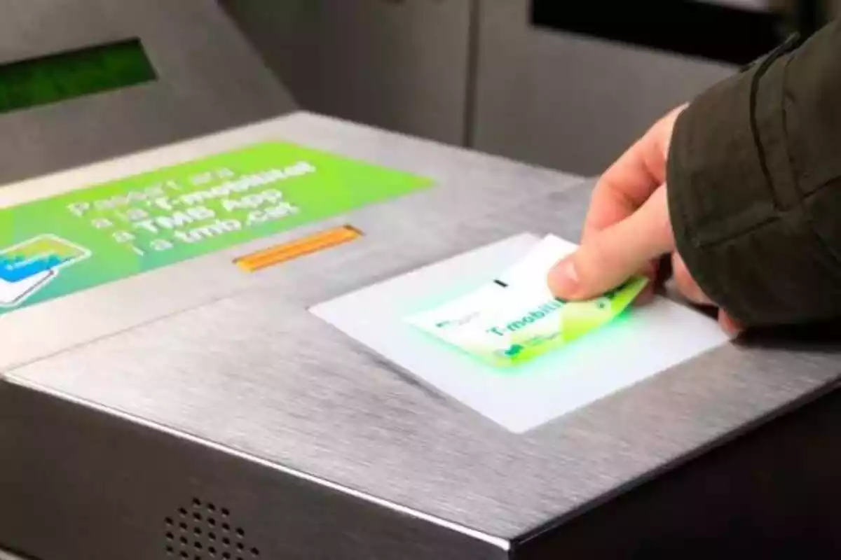 Una persona validant un títol de T-mobilitat al metro de Barcelona