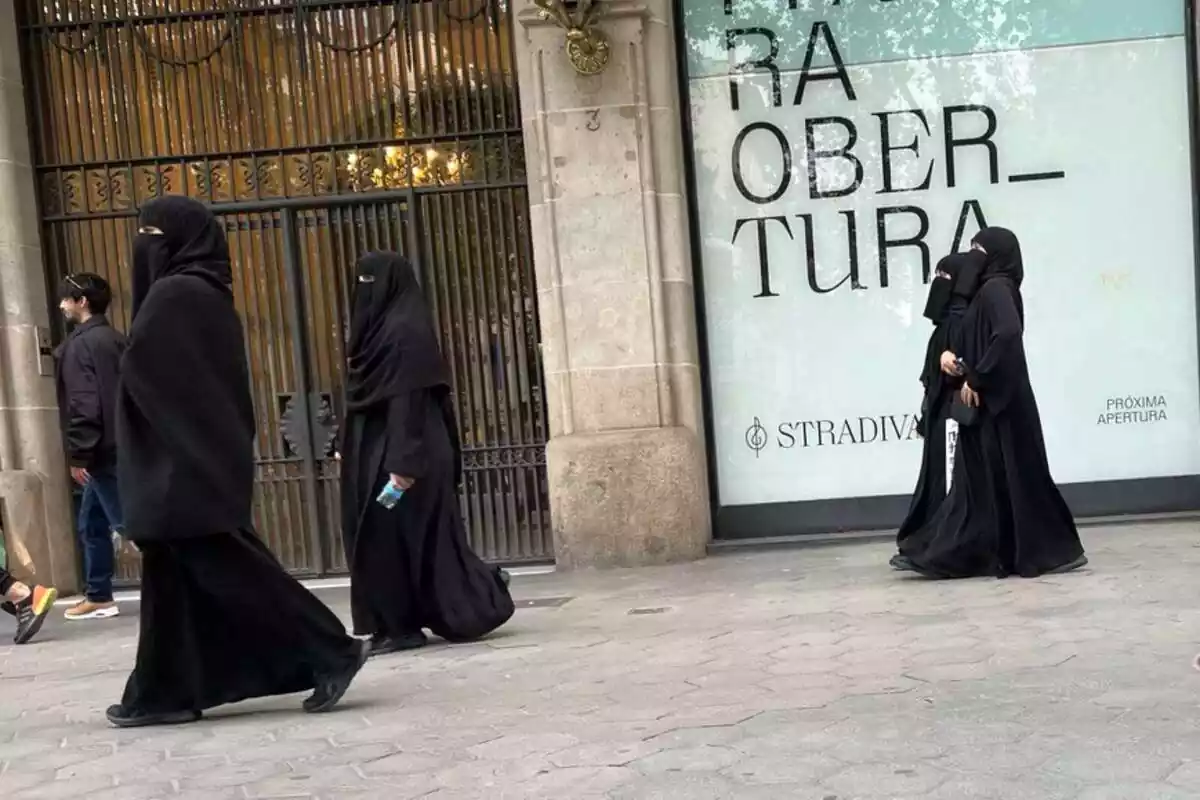 Diverses dones àrabs passejant pels carrers de Catalunya vestits amb niqab