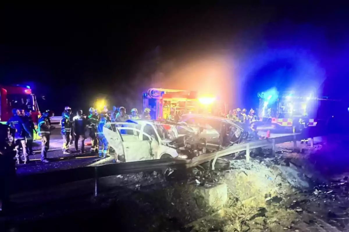 Accident automobilístic nocturn amb diversos bombers i vehicles d’emergència atenent l’escena il·luminada per les llums de patrulles i camions de bombers Accident automobilístic nocturn amb diversos bombers i vehicles d’emergència atenent l’escena il·luminada per les llums de patrulles i camions de bombers