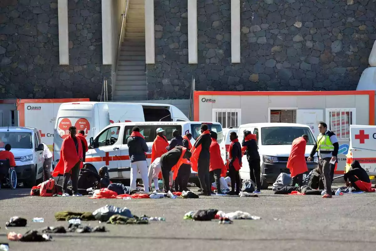 Diversos immigrants són atesos pels serveis d'emergències, alguns es cobreixen el cos amb una manta vermella