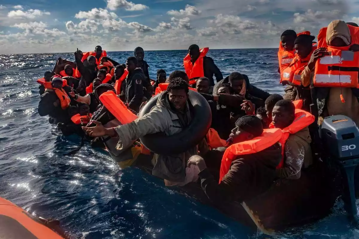 Diversos migrants viatjant en una piragua amb armilles salvavides al Mar Mediterrani