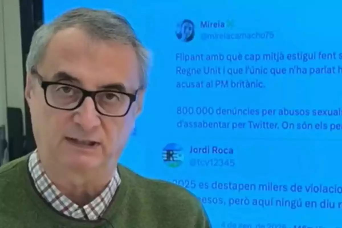 Un hombre con gafas y camisa a cuadros aparece frente a una pantalla azul con texto en catalán.