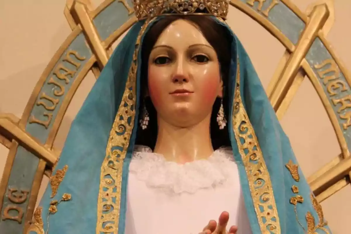 Una estàtua religiosa amb mantell blau i detalls daurats, amb una corona al cap.