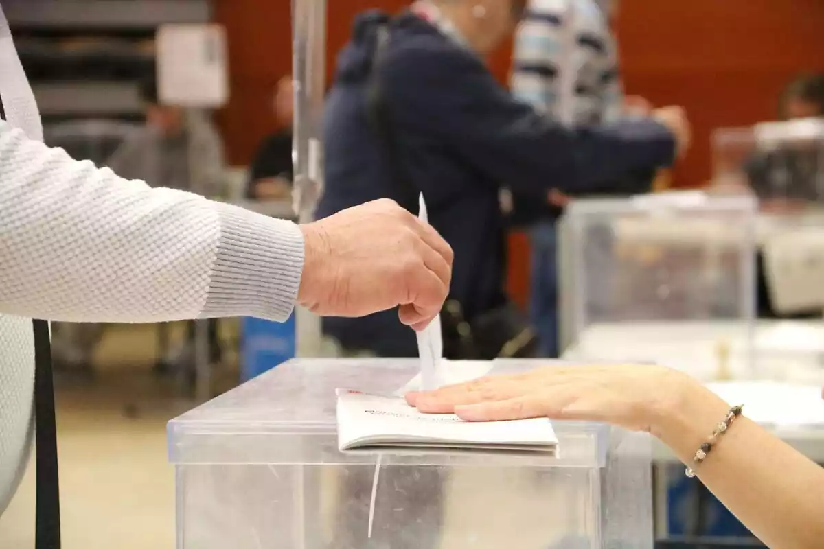Imatge d'una mà introduint un vot en una urna a les eleccions catalanes del 2024
