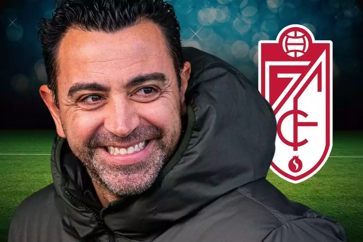 Xavi Hernández amb un gran somriure mirant de reüll l'escut del Granada CF