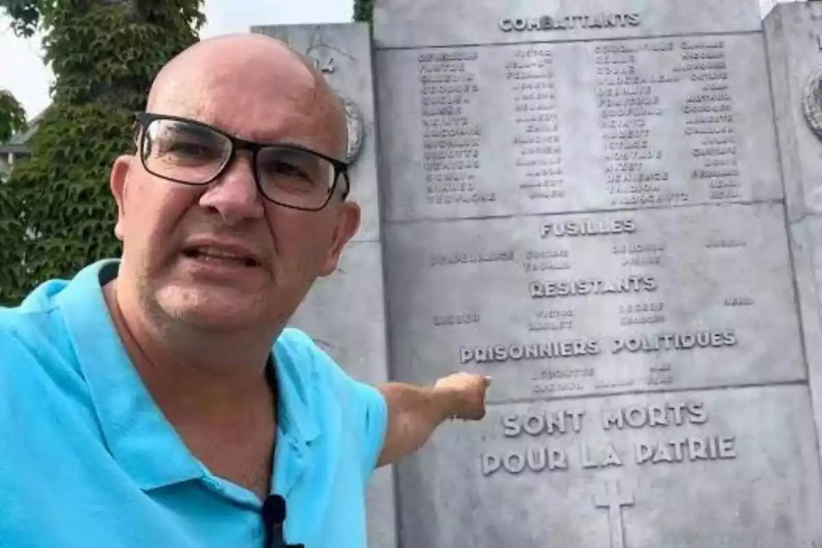 Primer pla de Xavier Rius assenyalant una placa commemorativa als caiguts a la batalla de Bastogne, Bèlgica, a la II Guerra Mundial