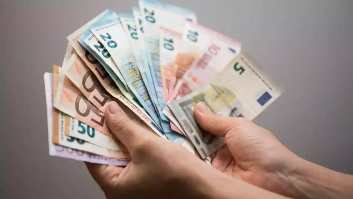 La mà d'una persona agafant molts bitllets d'euro, 5, 10, 20, 50 i 500